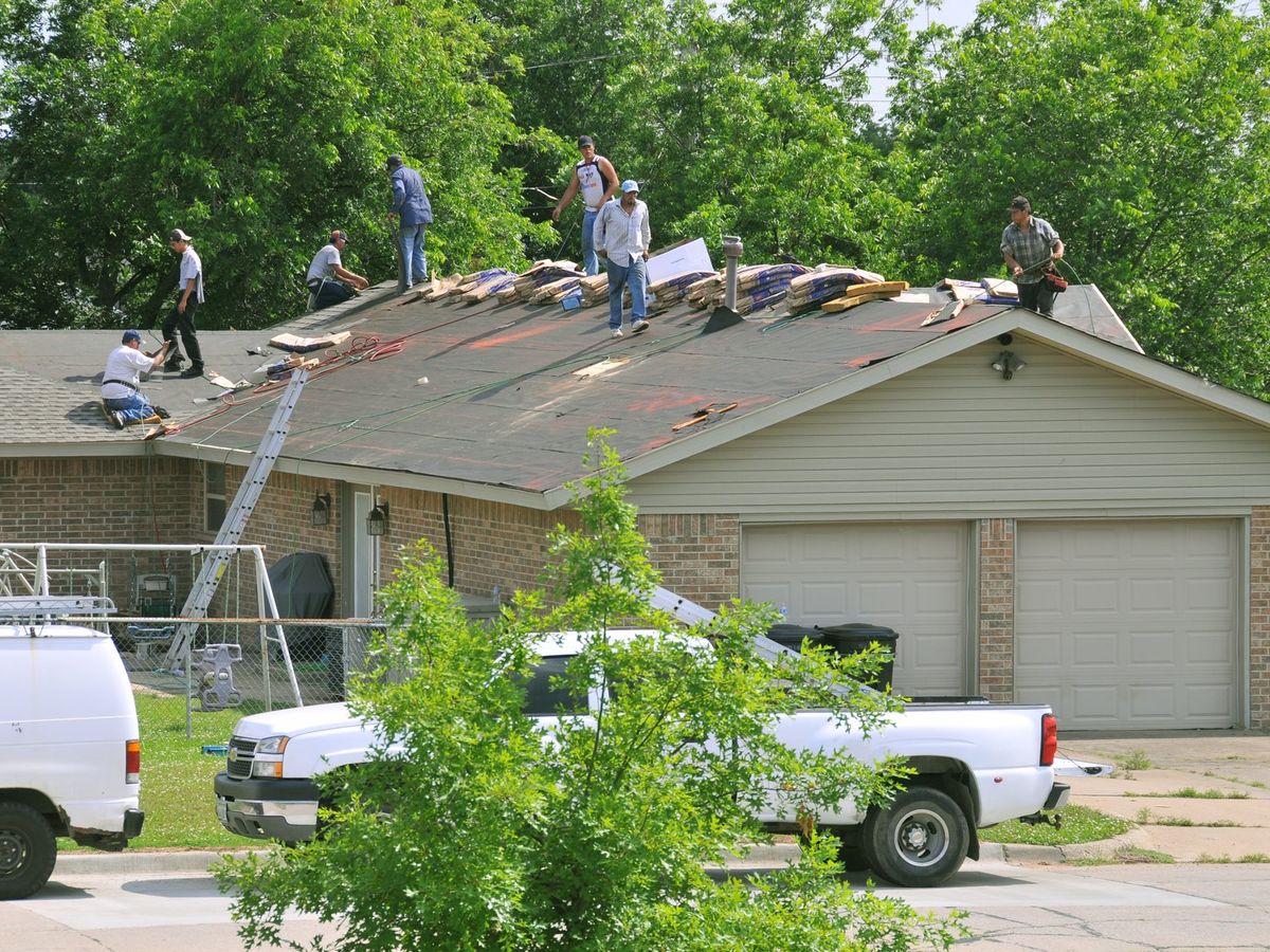 Roofing crew re-roofing a house after storm damage