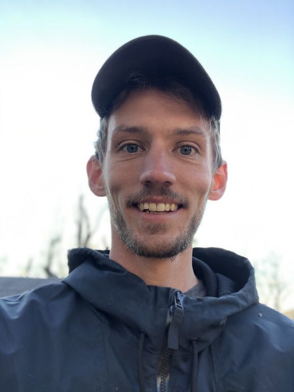 Russ with short hair and a cap